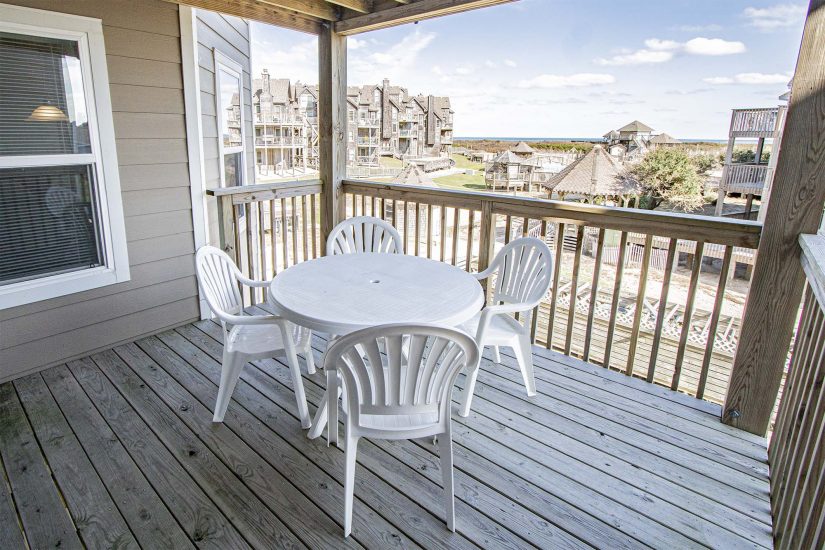 Balcony photo showcasing plastic round table with 4 chairs overlooking the resort.